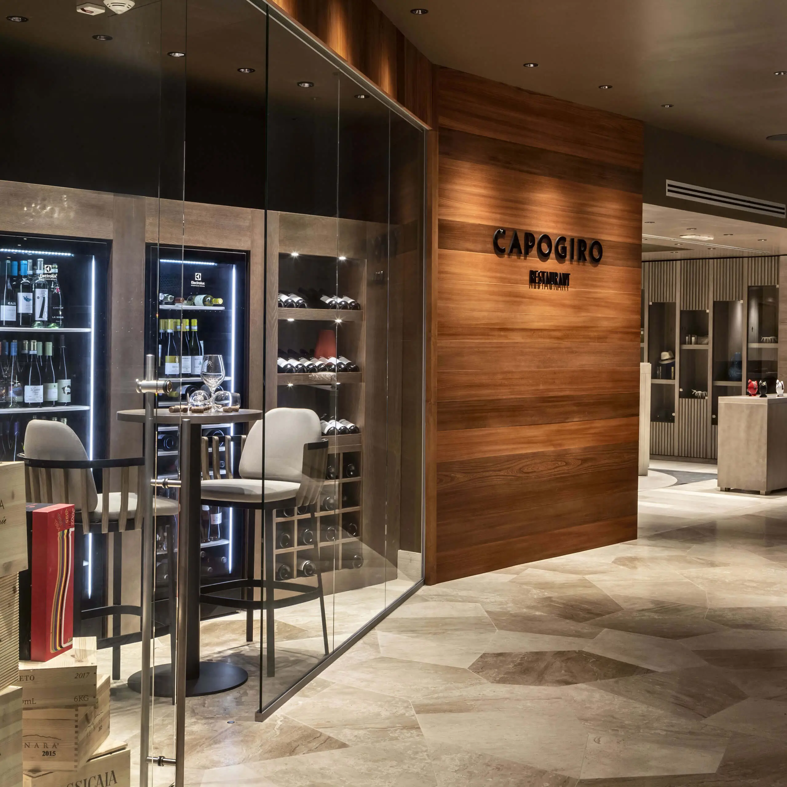Capogiro restaurant interior with glass wine display and stylish seating at 7Pines Hotels & Resorts.