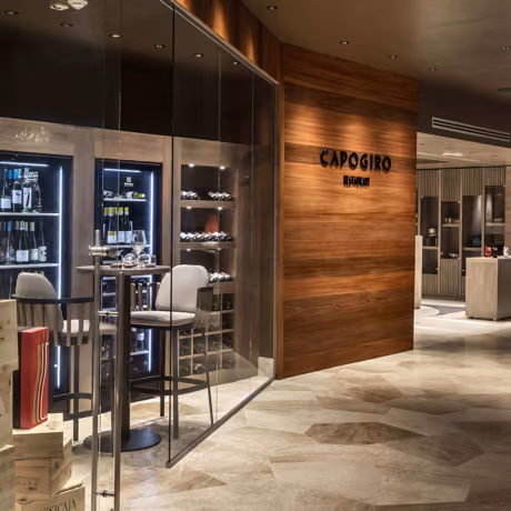 Capogiro restaurant interior with glass wine display and stylish seating at 7Pines Hotels & Resorts.