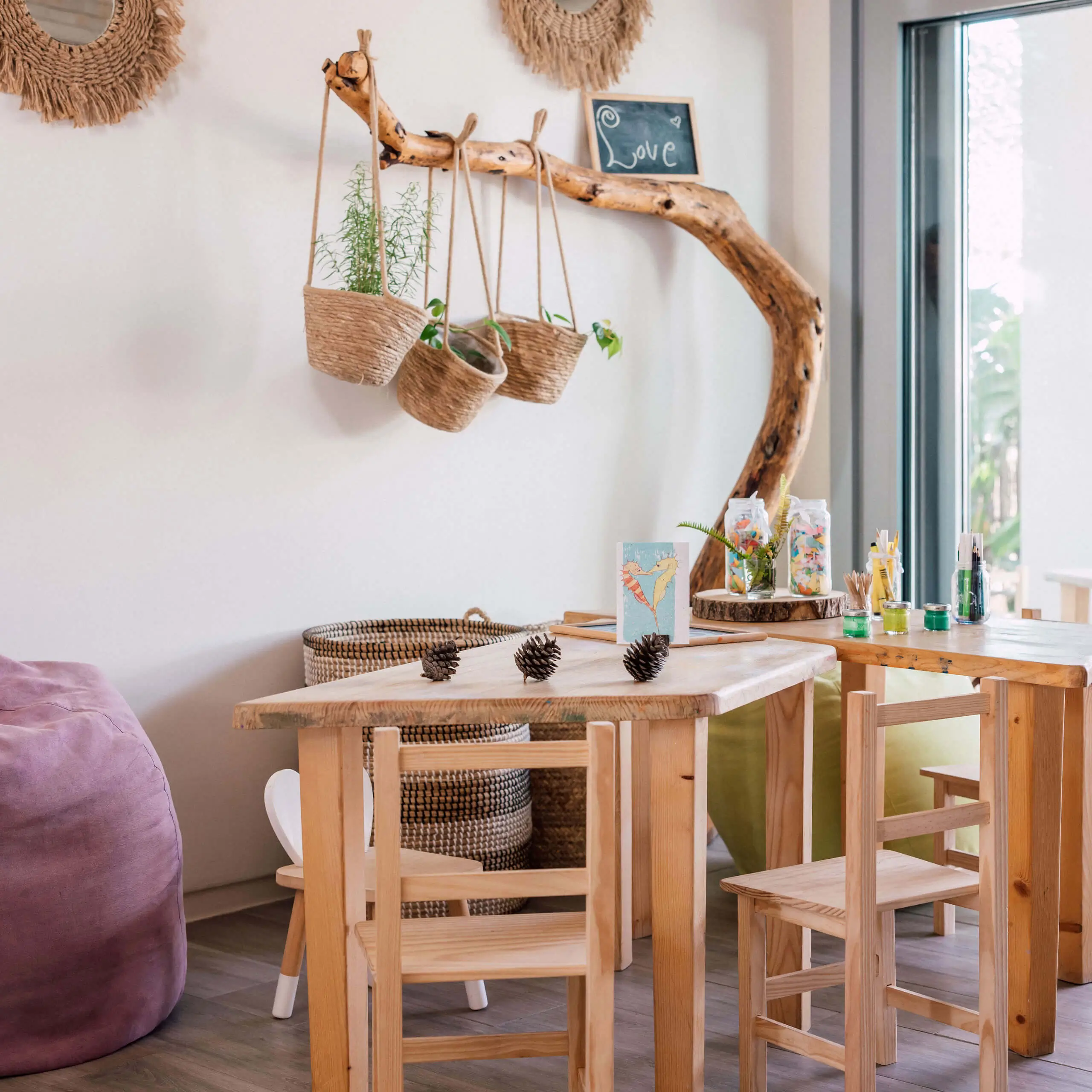 Heller Kids-Club-Aktivitätsraum im 7Pines Resort mit Holztischen für Kinder, natürlicher Dekoration und hängenden Pflanzkörben.