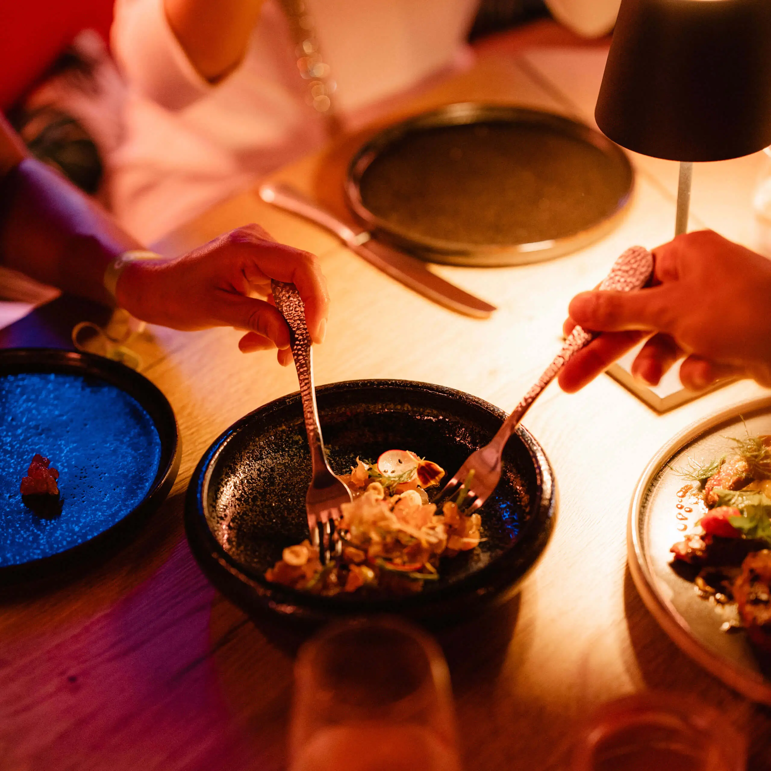 Guests sharing plated dishes at Cone Club, a refined dining experience at 7Pines.