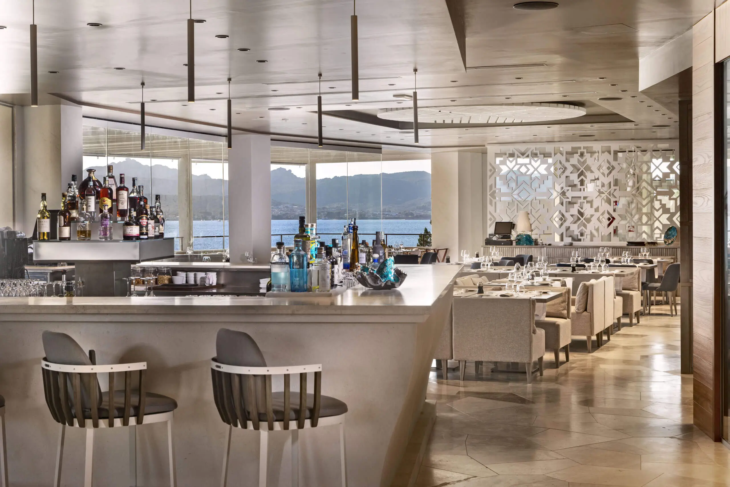 Stylish restaurant bar with elegant seating and a stunning sea view at 7Pines Hotels & Resorts.