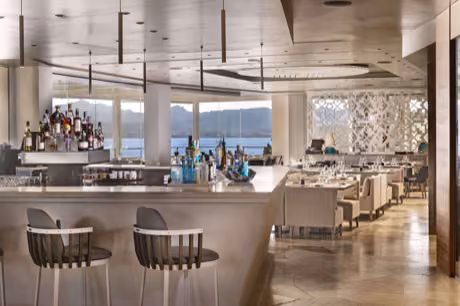 Stylish restaurant bar with elegant seating and a stunning sea view at 7Pines Hotels & Resorts.