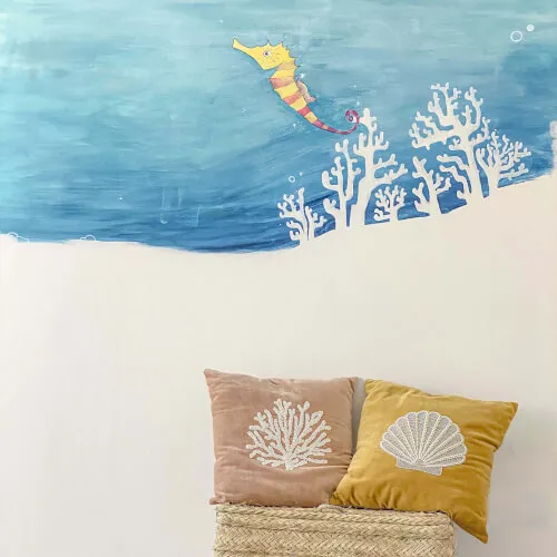 Colorful seahorse mural and decorative pillows at Kio House of Kids, 7Pines Hotels.