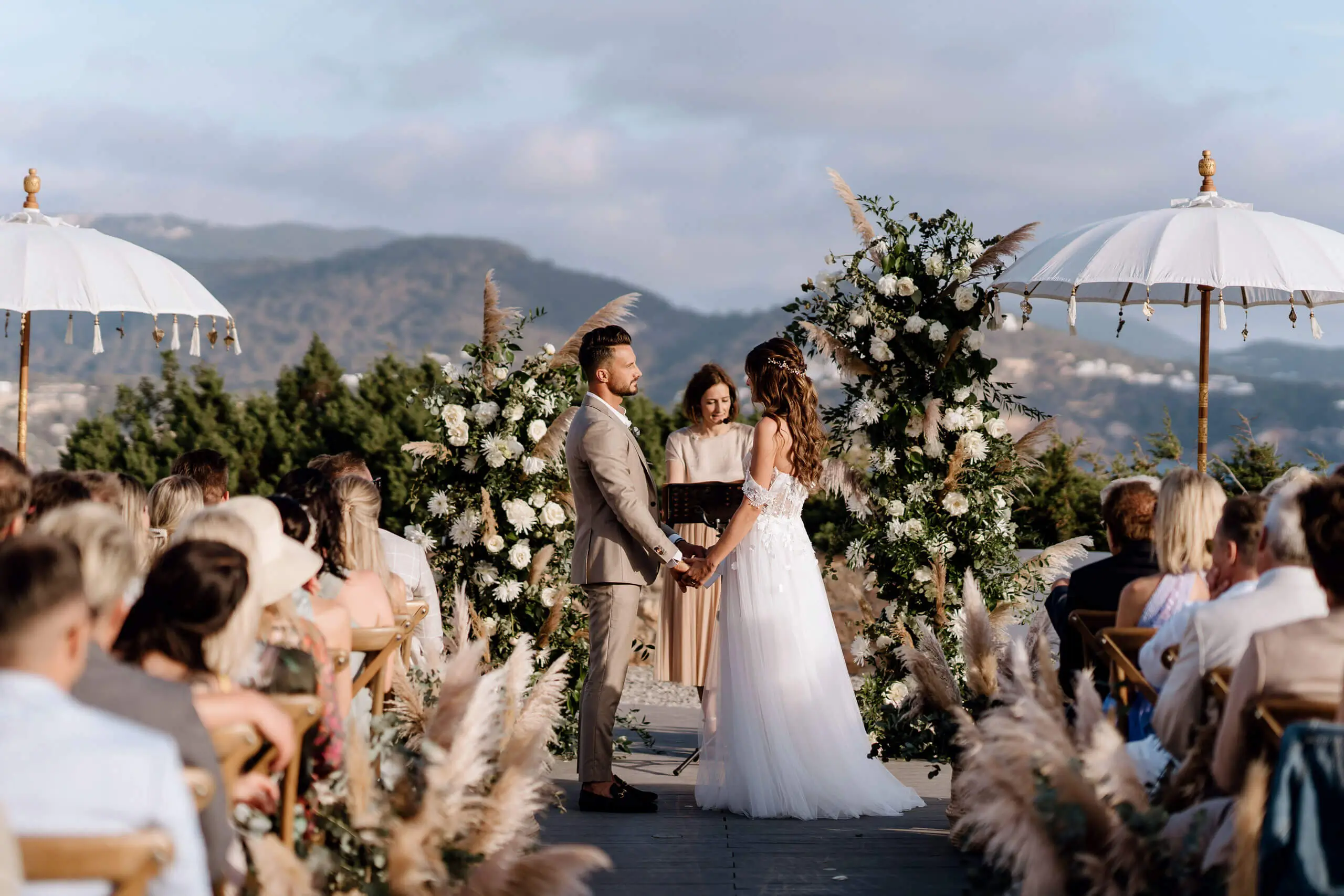 Ein Brautpaar tauscht am Hochzeitstag Gelübde mit atemberaubenden Blumenarrangements aus.